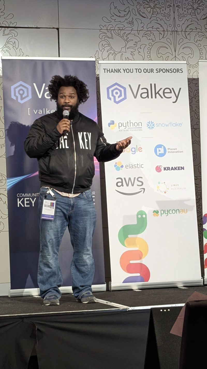 A speaker presenting at PyCon AU with Valkey as a sponsor